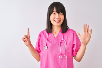 Wall Mural - Young beautiful Chinese nurse woman wearing stethoscope over isolated white background showing and pointing up with fingers number six while smiling confident and happy.