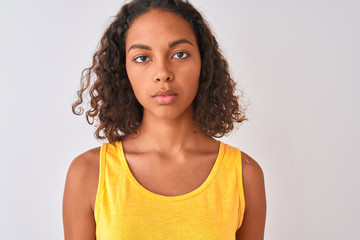 Young brazilian woman wearing t-shirt standing over isolated white background with a confident expression on smart face thinking serious