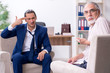 © Elnur - Young man visiting old male doctor psychologist