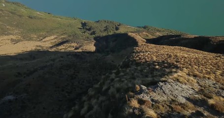 Wall Mural - adventurous female hiking along ridge, panorama over steep mountain landscape in new zealand