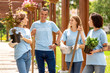 © Viktoriia - Volunteering. Young people volunteers outdoors standing with pots and equipment for planting talking smiling happy