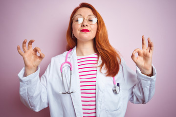 Sticker - Young redhead doctor woman wearing glasses over pink isolated background relax and smiling with eyes closed doing meditation gesture with fingers. Yoga concept.