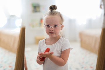 child toddler girl in glasses with down syndrome