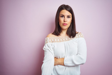 Poster - Young beautiful brunette woman over pink isolated background with serious expression on face. Simple and natural looking at the camera.