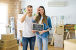 © Krakenimages.com - Young beautiful couple holding blackboard with new home text at new house with happy face smiling doing ok sign with hand on eye looking through fingers
