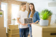 © Krakenimages.com - Beautiful young couple moving to a new house, smiling very happy holding blackboard with new home text