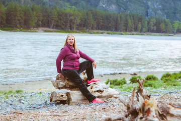 Wall Mural - an elderly woman sitting near the river