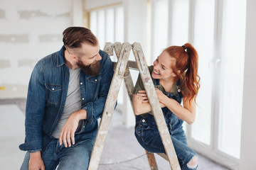 Playful young couple doing home renovations