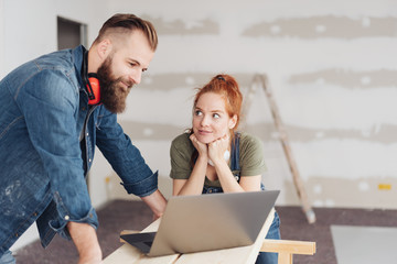 Couple working with a laptop during renovations