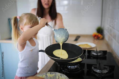 Cuadros en Lienzo Mom and daughter fried pancakes together