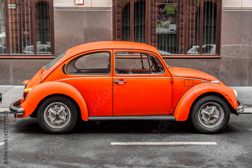 Photographie BUDAPEST, SEPTEMBER 17: Orange retro car Volkswagen Beetle parked on the old street on September 17, 2016 in Budapest, Hungary