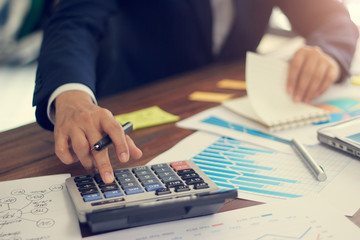 Poster - Businessman using calculator to calculate budget and analyzing sales data and growth graph, Payments, Business financing and accounting banking.