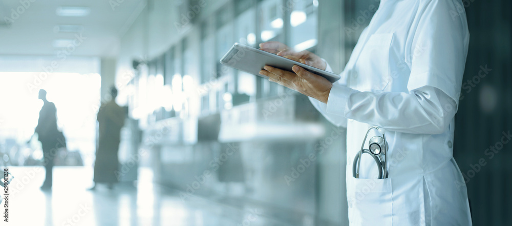 Healthcare and medicine. Medical and technology. Doctor working on digital tablet on hospital background - obrazy, fototapety, plakaty 