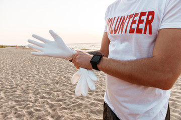 Wall Mural - Young man volunteer standing at the beach