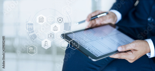 Fotografía Health care insurance concept, Businessman completing a medical claim form with insurance icon health care on tablet digital