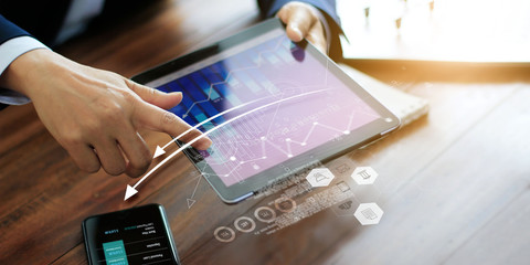 Poster - Businessman using tablet analyzing sales data and economic growth graph. Business planning and strategy. Digital marketing.