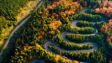 Aerial View Of Forest Road In Beautiful Autumn .at Sunset. Mountain Roads Details With Colourful Landscape With Heavy Traffic And Yellow Trees