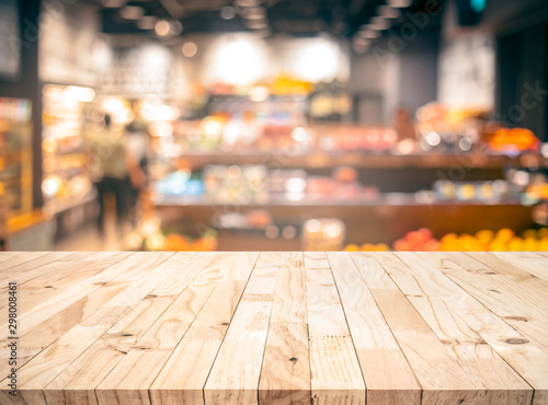 Fotomural Wood texture table top (counter bar) with blur grocery,market store background