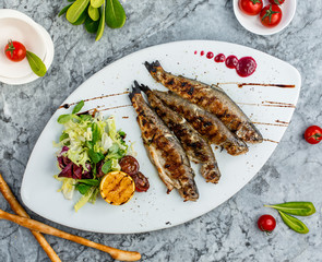 Poster - fried fish with vegetables on the table