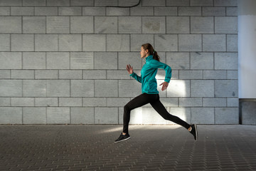 Young adult athlete woman jogging outdoor in city