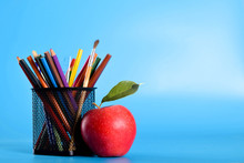  School Supplies Pencils, Pens, Ruler, Brush , Books And Apple On A Blue Background With A Place For Text