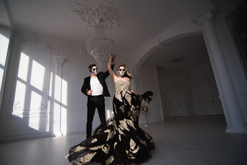 Couple with dark skull makeup on white background. Halloween