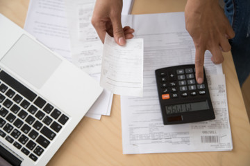 Close up of woman calculating expenses considering bills