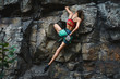 © vitaliymateha - young slim muscular woman rockclimber climbing on tough sport route, chalking hands.