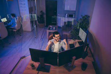 Poster - Hign angle view photo of it skilled specialist guy sitting chair celebrating startup success looking many monitors team finished server debugging tasks night office indoors