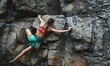 © vitaliymateha - Sports woman with slim fit body climbing on the rock, having workout, climber makes a hard move.