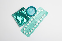 Condom And Birth Control Pills On Light Grey Background, Flat Lay. Safe Sex Concept