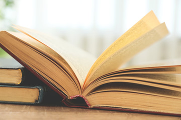 Wall Mural - Open hardcover book on wooden table indoors, closeup