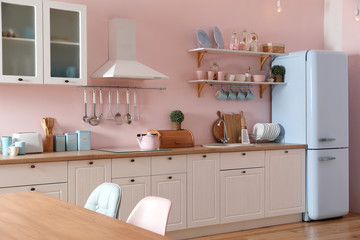 Wall Mural - Stylish pink kitchen interior with dining table and chairs