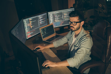 Sticker - Profile side view of nice attractive serious smart clever bearded brunet guy sitting in chair editing creating database bug tracking report web content display in dark beige room workplace station