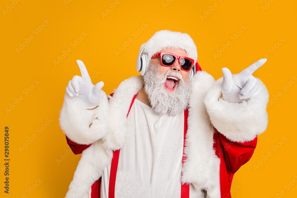 Nightclub invite on christmas party celebration funky crazy santa claus dj in white headset sing song sound melody listen music dance wear stylish x-mas hat suspenders isolated yellow color background - obrazy, fototapety, plakaty 