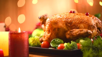 Wall Mural - Christmas Roasted Chicken Dinner. Winter Holiday table served, decorated with candles. Delicious Steamed Roast chicken over wooden background with Christmas gifts, table setting. Dolly shot 4K UHD