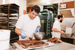 © Alberto Menendez/ADDICTIVE STOCK - Concentrated pastry cook smearing chocolate topping on tasty cake while standing near table in bakery