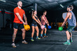 © Aparicio Febrer/ADDICTIVE STOCK - Muscular fellows with coach lifting up kettle bells while functional training in contemporary health club