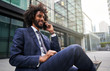 © Fernando Perez/ADDICTIVE STOCK - Joyful ethnic man in suit sitting outside and talking phone