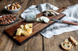 © Pablo Garcia/ADDICTIVE STOCK - Sweet croutons with raisins and plate with almonds placed on wooden table near board with various cut cheese