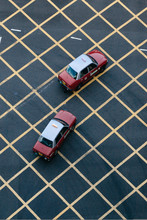 From Above View Of Red Taxi Cars Crossing Box Junction With Yellow Cross Lines