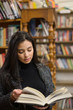 © Lauren Naefe/Stocksy - Woman reading in bookstore