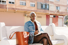 Black Lady Sitting On Bench On Street