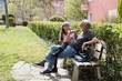 © Garage Island Crew/Stocksy - Happy senior couple on teh bench outdoors