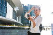 © Garage Island Crew/Stocksy - Blonde businesswoman using a phone in the city