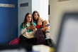 © ALTO IMAGES/Stocksy - Teenagers using mobile phone on a school break