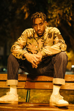 Black Man Sitting On Bench At Night