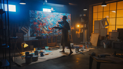 Fototapete - Talented Female Artist Energetically Draws with Paint Brush, She Creates Modern Masterpiece of the Oil Painting. Creative Studio with Large Canvas of Striking Colors.