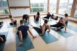 © Rob and Julia Campbell/Stocksy - Yoga class sitting on mats in studio.