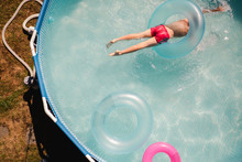 Little Boy With Goggles In A Kiddie Pool